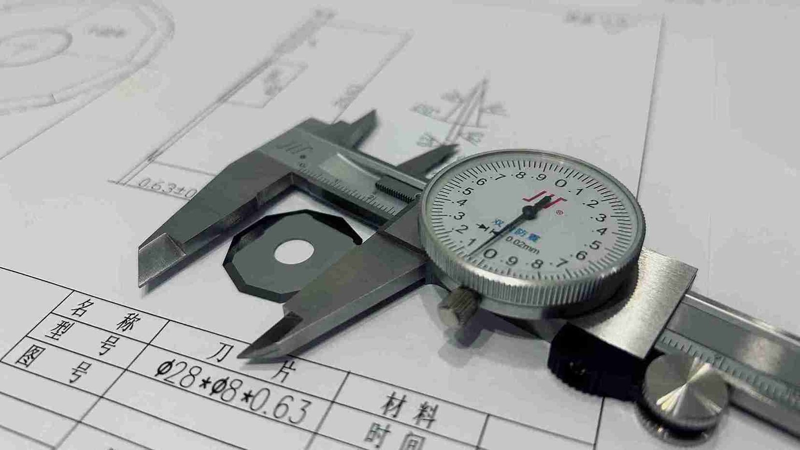 A checklist and tools like calipers and gauges next to an industrial blade.