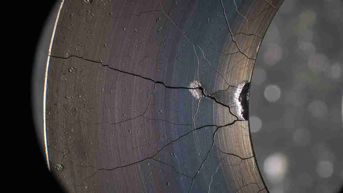 A close-up image of a blade edge showing signs of heat damage and micro-cracks