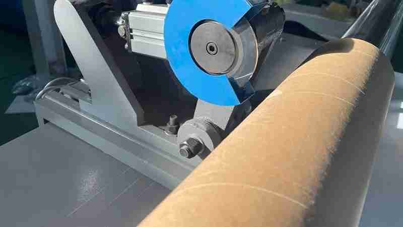 A close-up of a tube slitting blade cutting a paper core