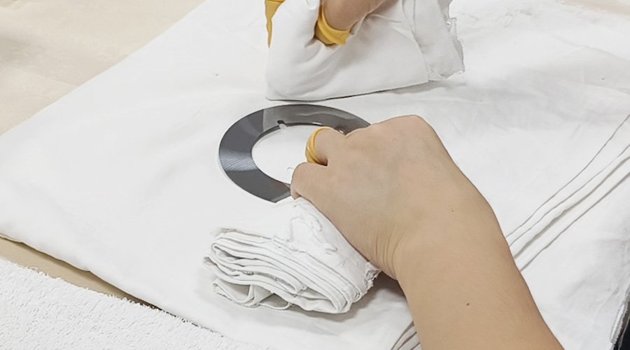 A hand wiping a large industrial knife dry