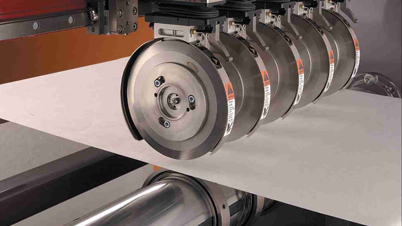 A slitting machine with a close-up on the slitting knives and pressure adjustment knobs.