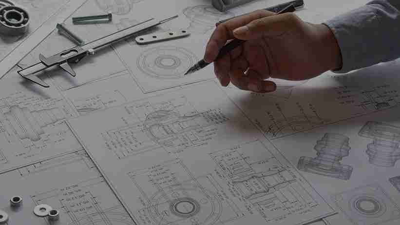 An engineer reviewing technical drawings and machine specifications