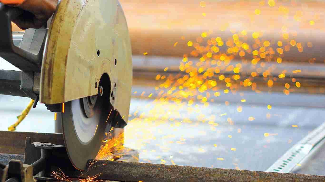 An industrial cutting machine in operation with a focus on the blade and sparks.