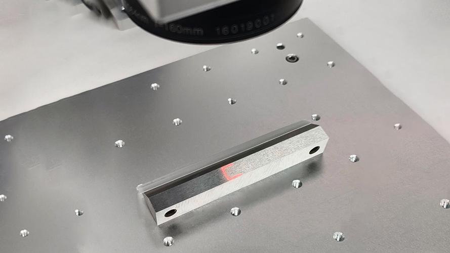 A laser etching a part number and logo onto a finished blade