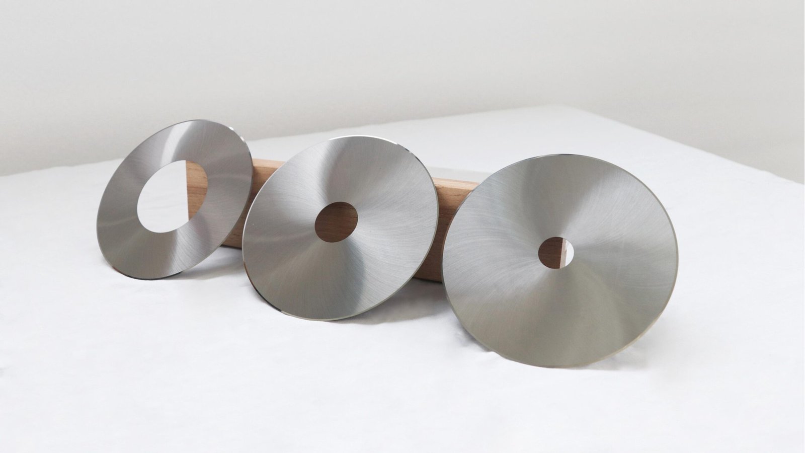 A carbide tobacco blade next to a standard steel blade showing less wear