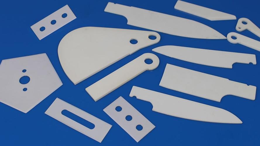 A ceramic blade cutting food products on a conveyor belt