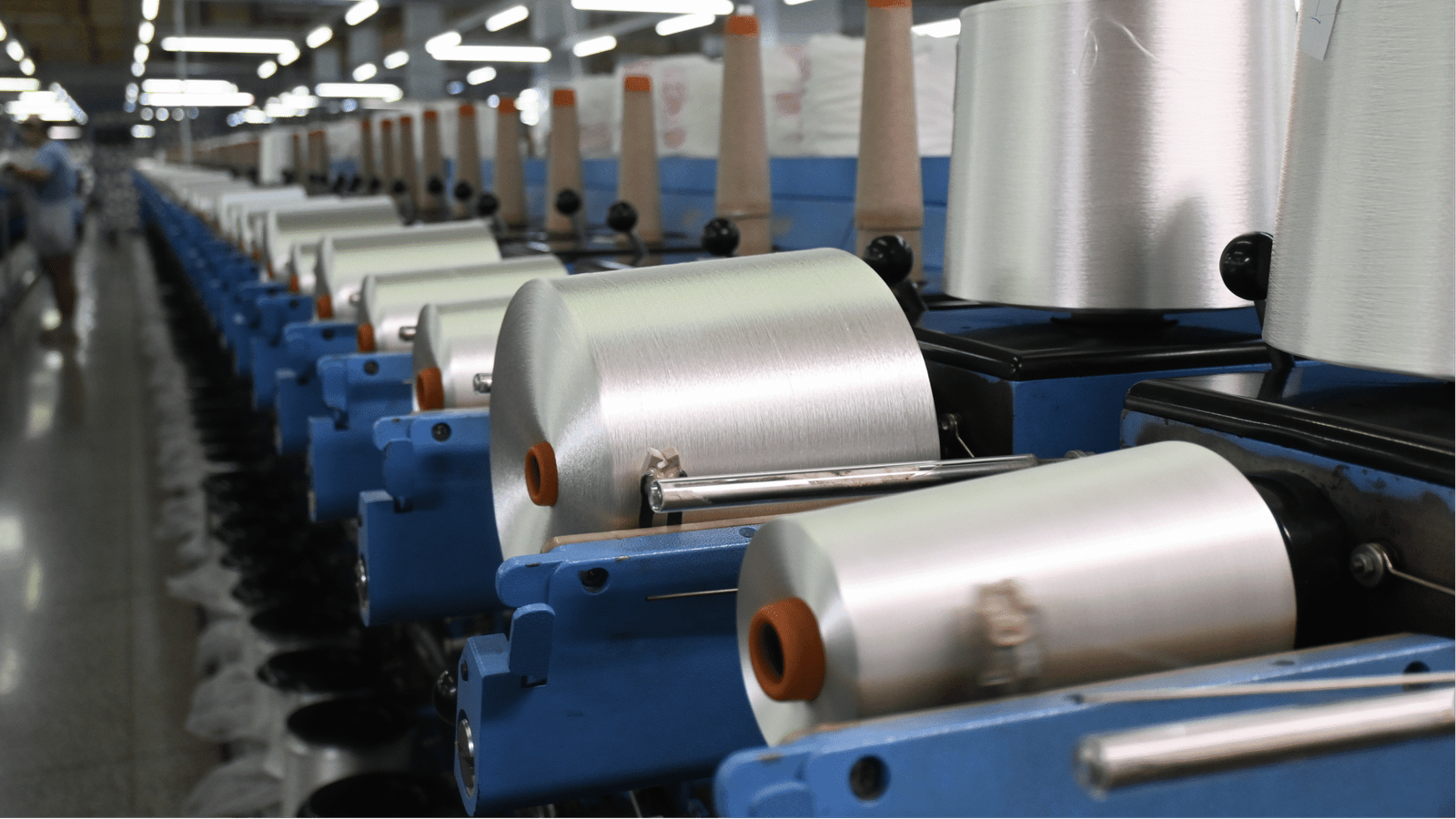 A close-up of a precision industrial blade cutting clean lines into synthetic fiber material.