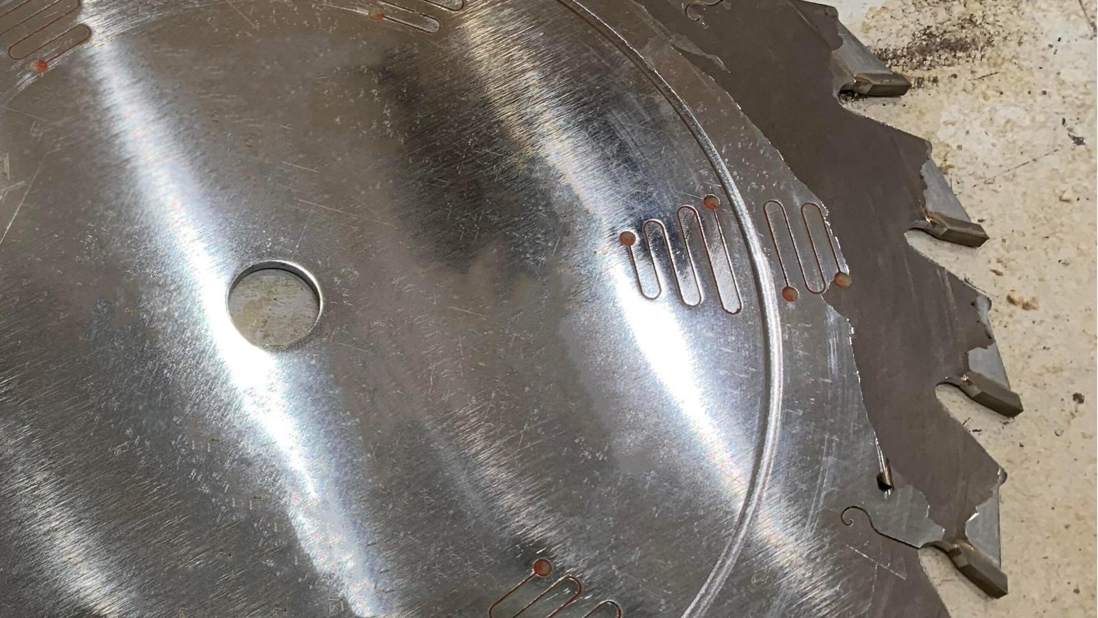 A coated industrial blade showing signs of wear and peeling