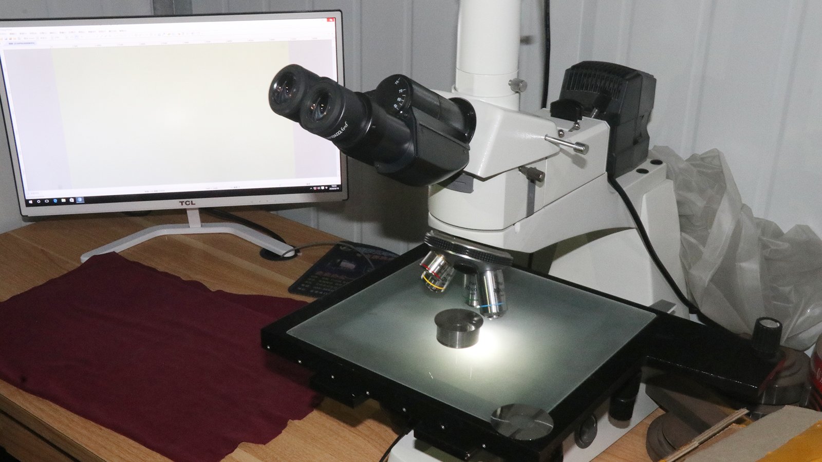 Engineer inspecting a blade with a microscope