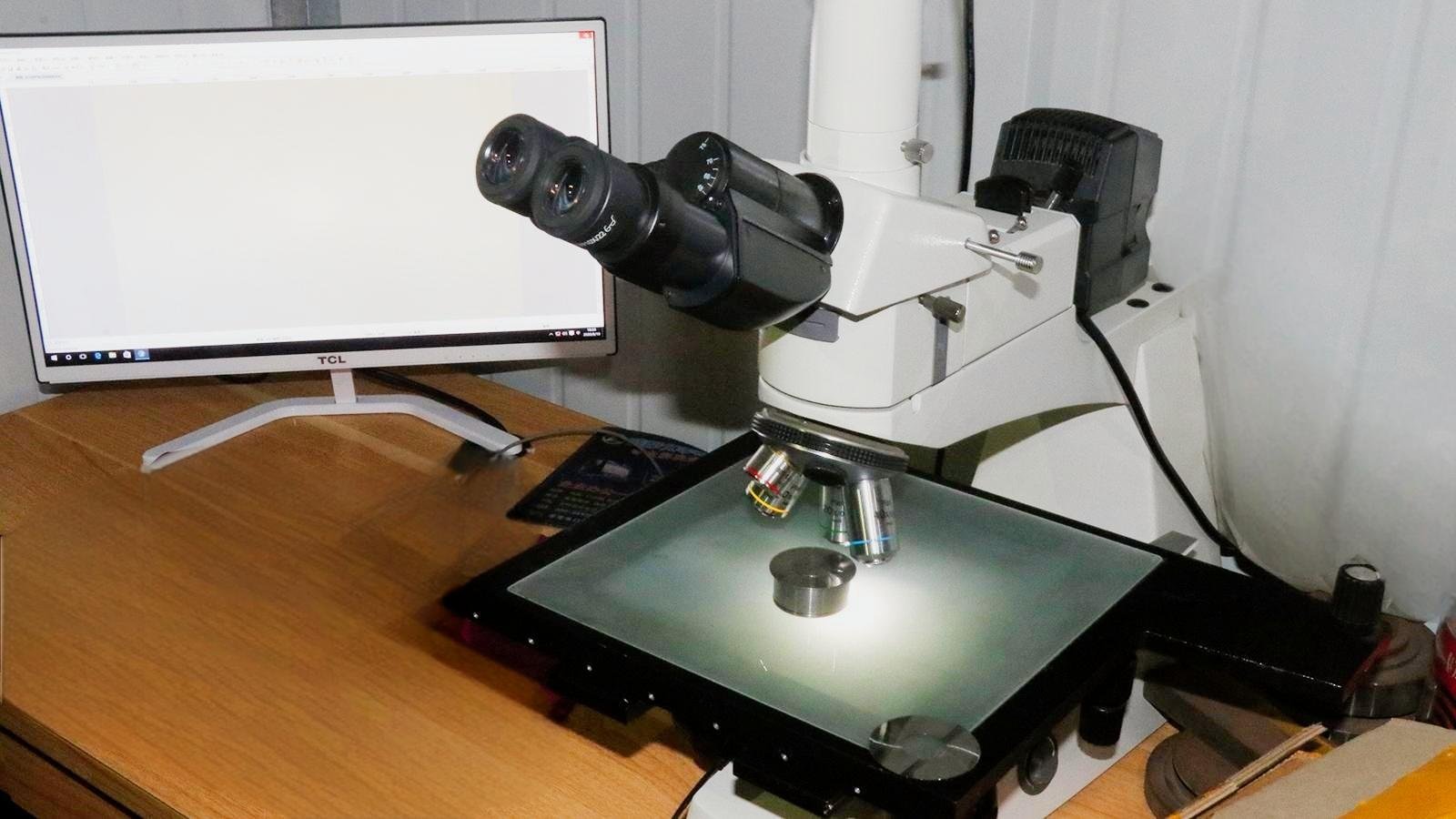 A quality control engineer inspecting an industrial blade with precision instruments