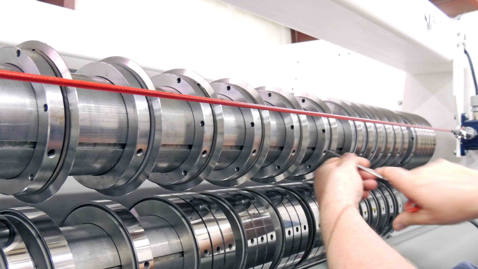 A close-up view of a rewinder bottom knife installed on a slitting machine