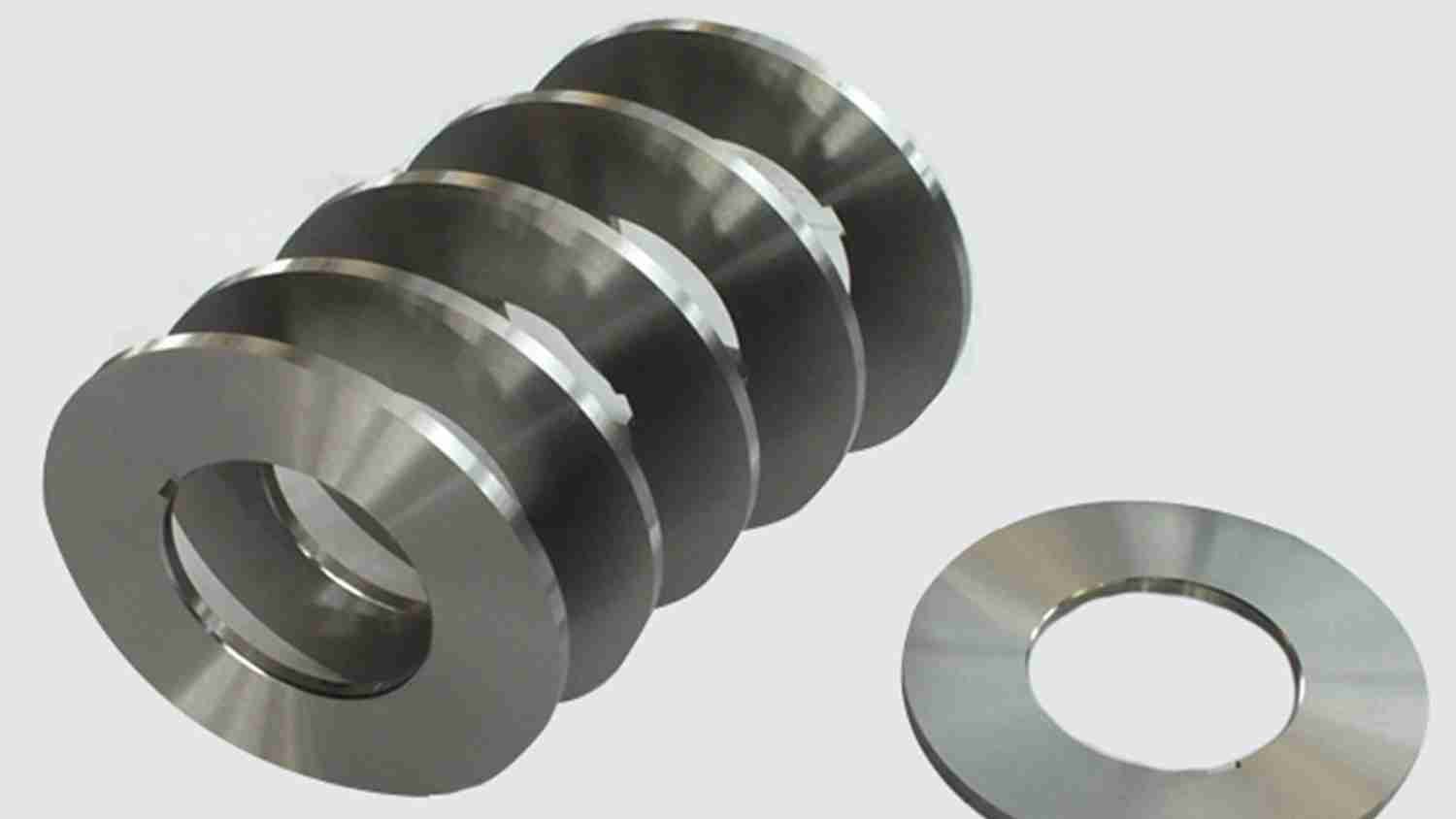 A display of metal slitting spacers made from different materials, like stainless steel and tool steel