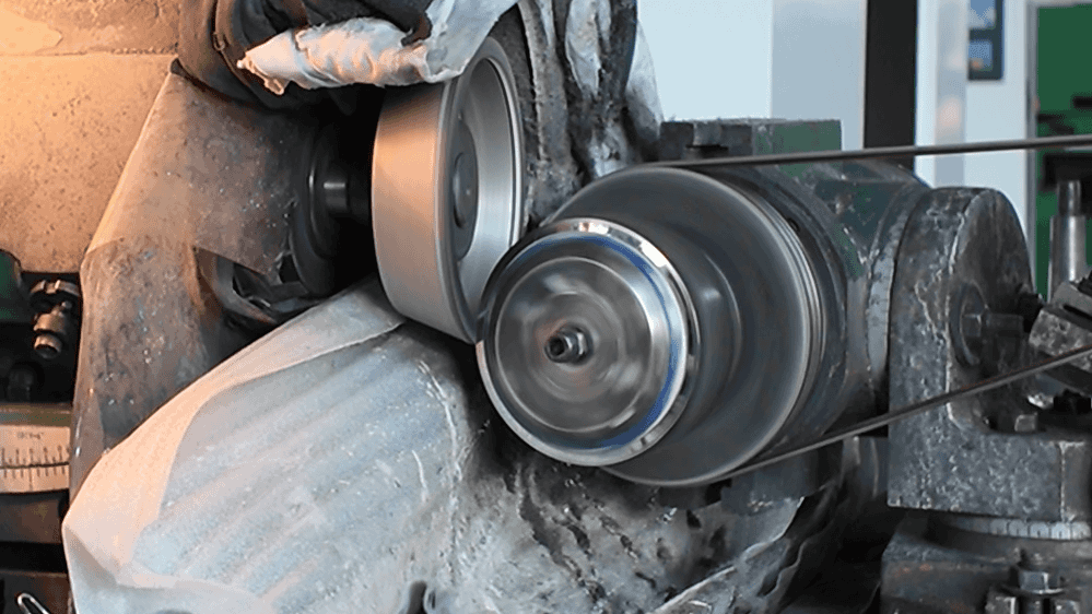 A user easily re-sharpening a carbon steel blade on a simple bench grinder.