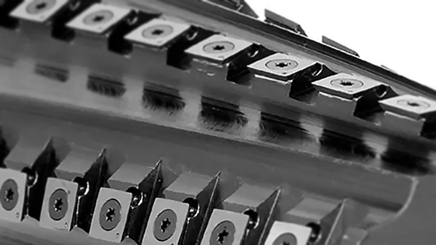 A close-up of a dual-clamp system holding an indexable blade securely in a boring bar.