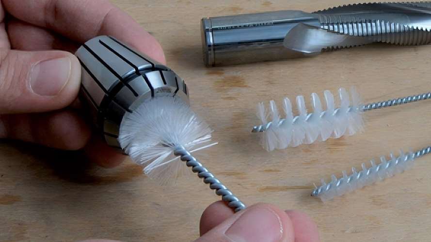 A technician cleaning a cutter holder before installing a blade