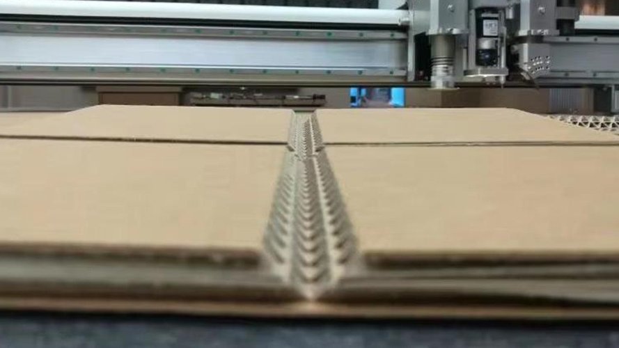 Close-up of bevel cutting blade processing corrugated cardboard