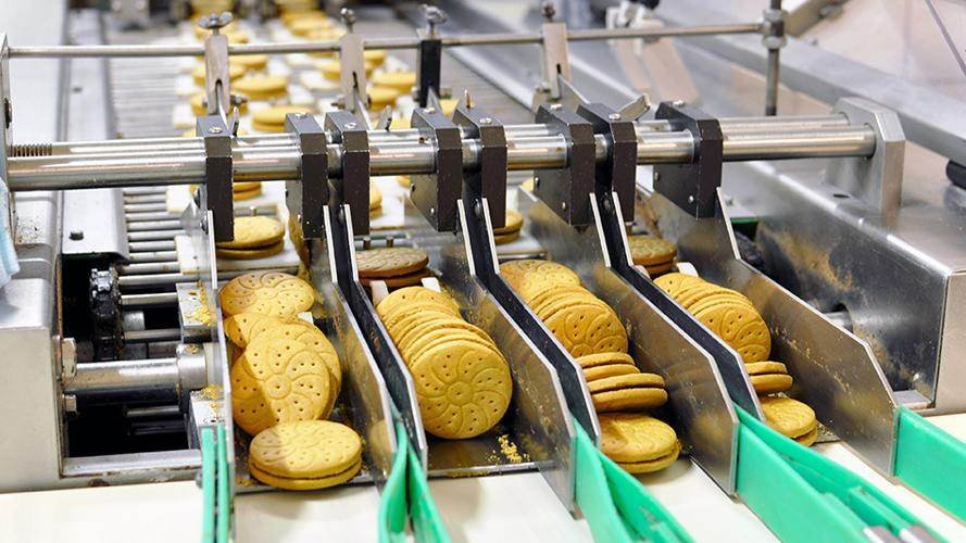 A sharp stainless steel circular blade slicing meat.