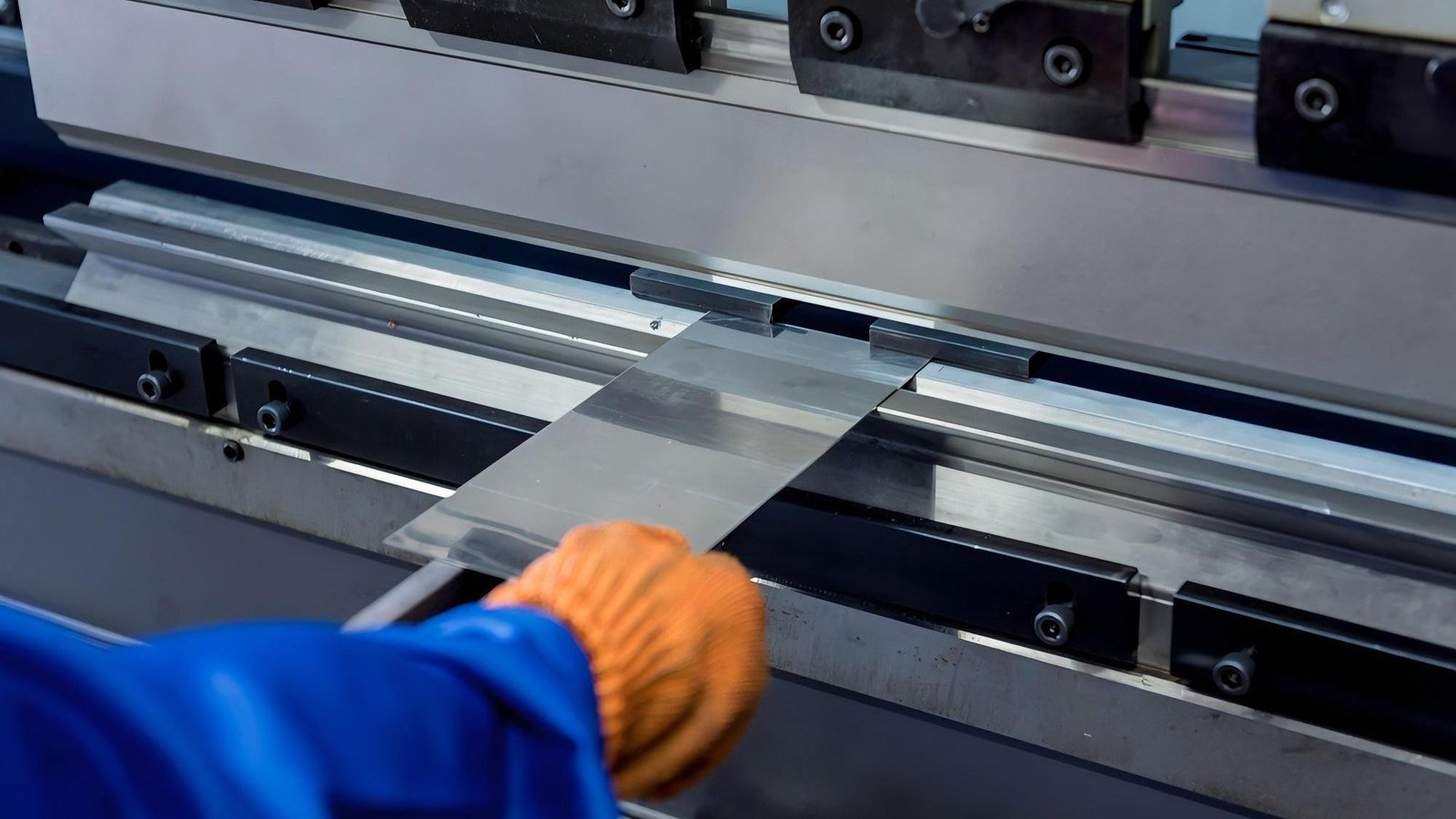 An industrial slitting machine cutting through a thick roll of metal.