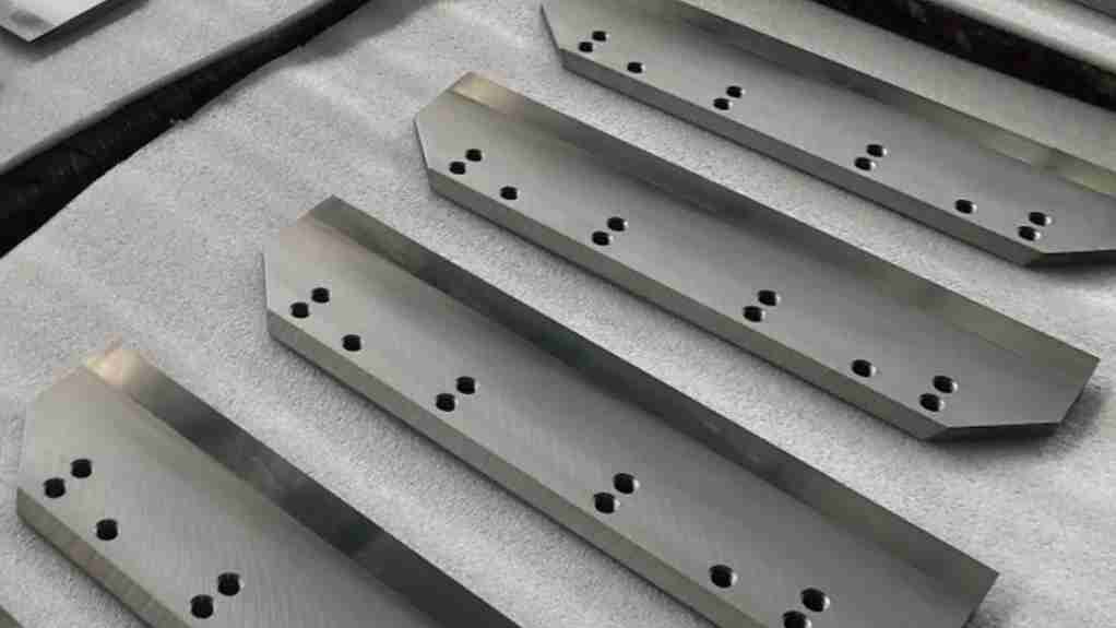 Inlay welded blade cutting through rolls of material