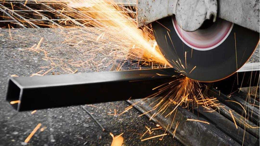 A CNC machine easily shaping a carbon steel blade blank with sparks flying.