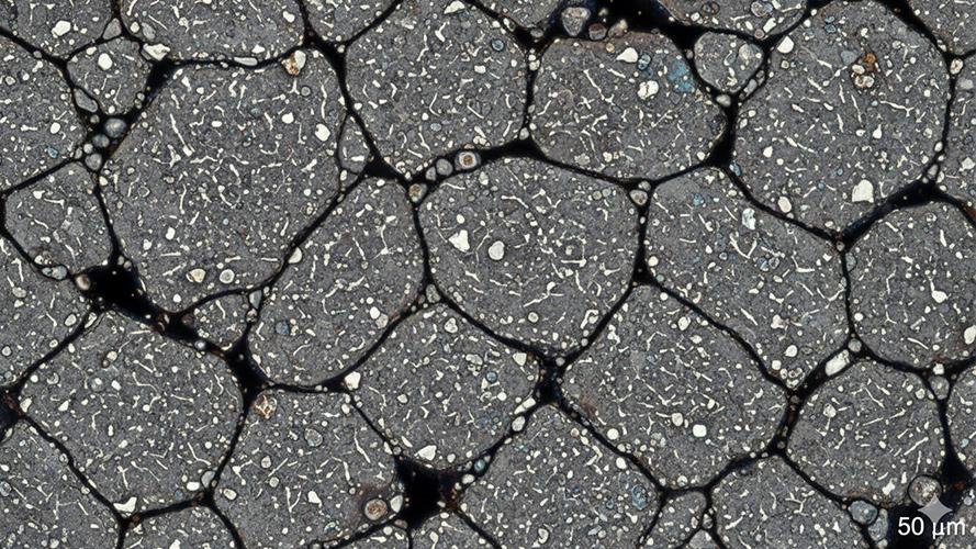 A detailed microscopic view showing the uniform grain structure of powdered steel.