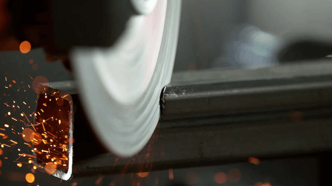 A PCBN blade cutting through a piece of hardened steel with sparks.