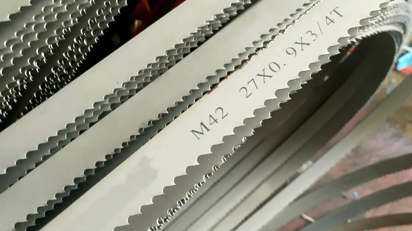 A person measuring the width of a bandsaw blade with calipers